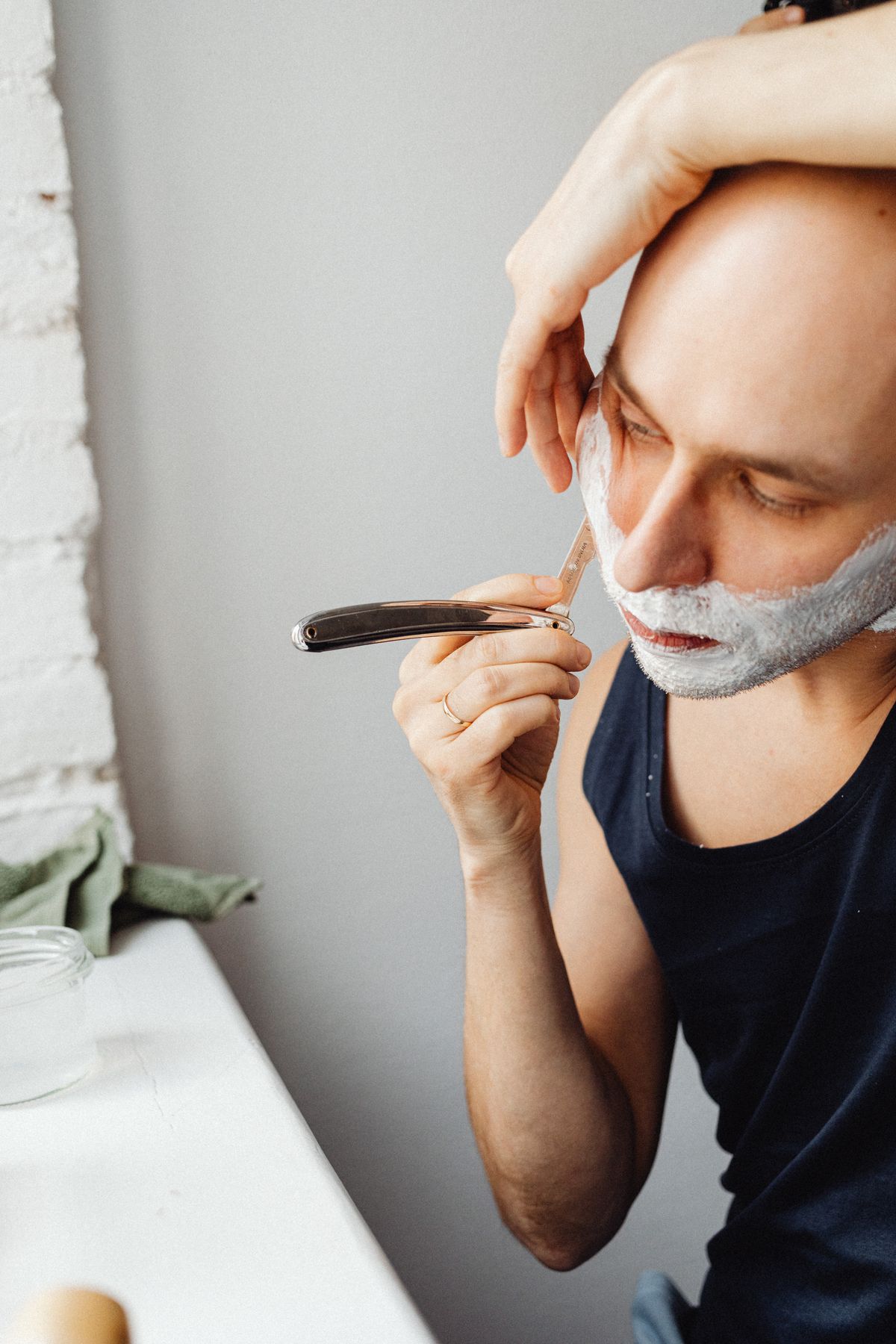 Homem fazendo a barba com lâmina e creme de barbear