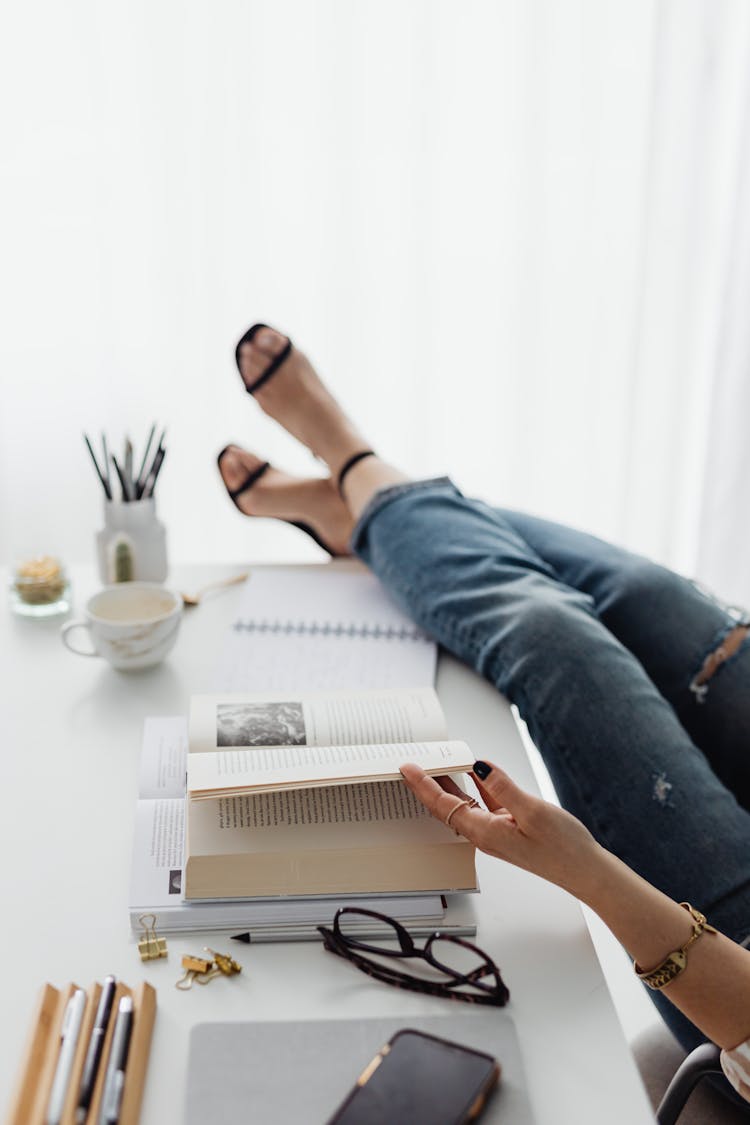 A Woman Sitting On Chair With Her Feet On The Table