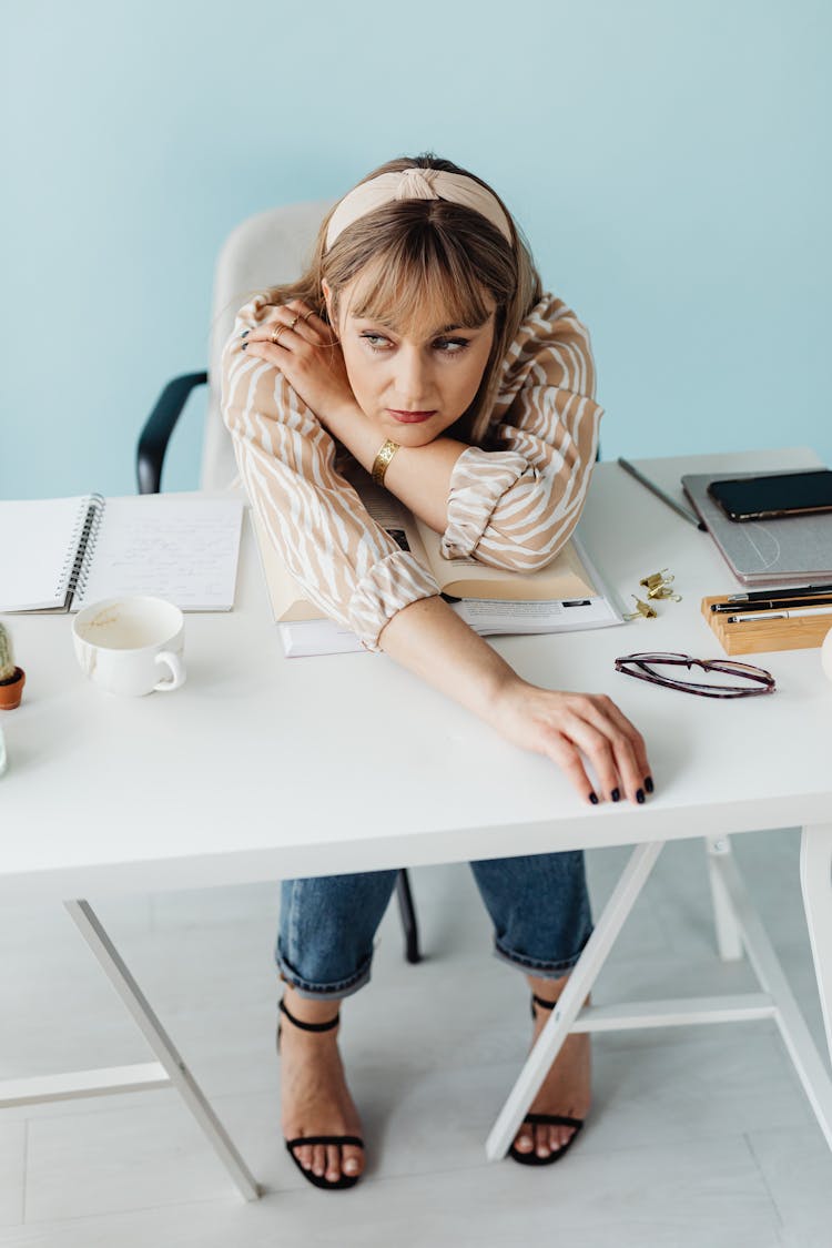 A Woman Leaning Forward On A Desk