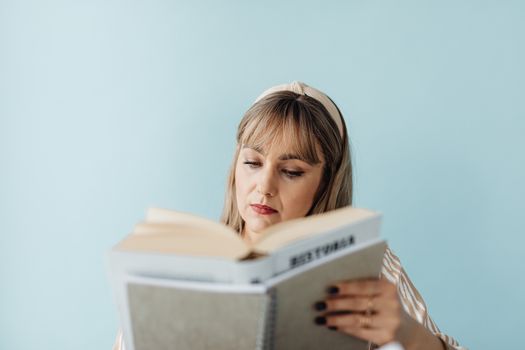 Photo of a Woman with a Beige Headband Reading a Book