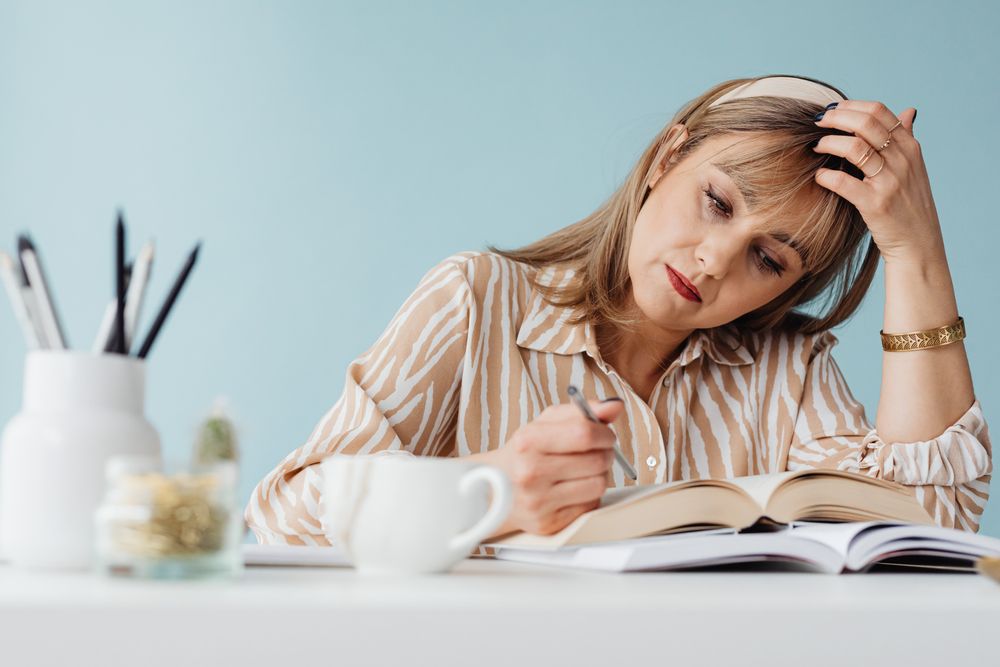 Junge Frau liest und schreibt konzentriert in einem Buch