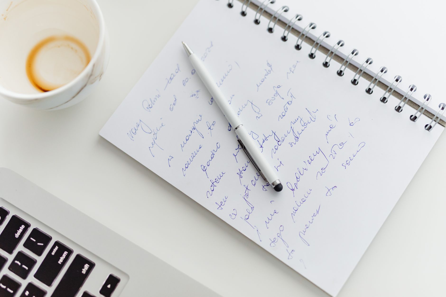 notebook with brainstormed words and a pen on a clean desk