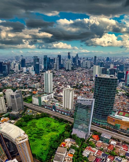 Free A breathtaking aerial view of Jakarta's skyline, featuring skyscrapers and lush greenery. Stock Photo