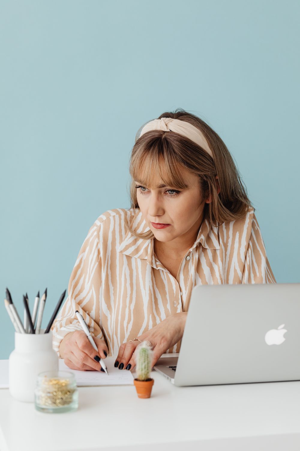 Woman in a Striped Blouse Writing in a Notepad · Free Stock Photo
