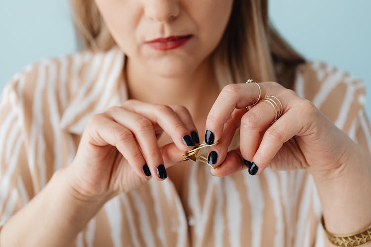 Woman Fidgeting With Gold Paperclip