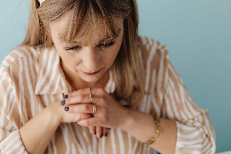 Woman With Clasped Hands Looking Down 