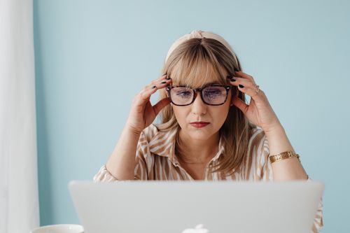 Free Woman with glasses concentrating on laptop work in a calm indoor setting. Stock Photo