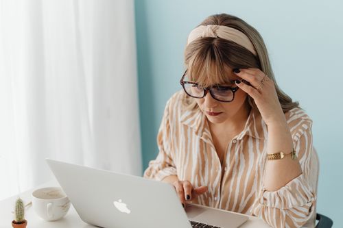 Free A woman in a cozy home office environment, appearing frustrated while working on a laptop. Stock Photo