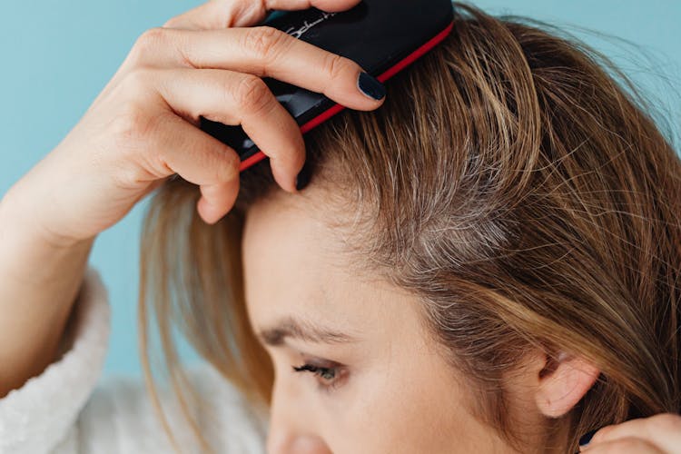 A Close-up Shot Of A Woman Brushing Her Hair