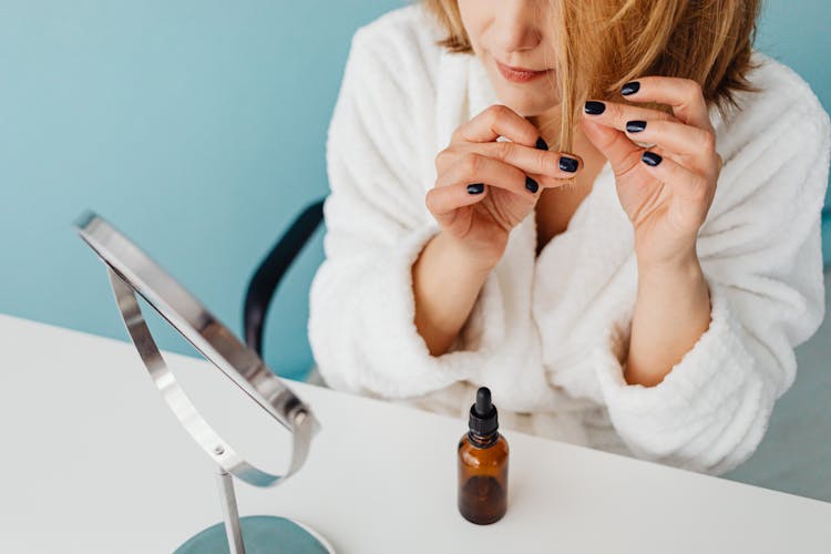 Woman Applying A Product To Her Hair