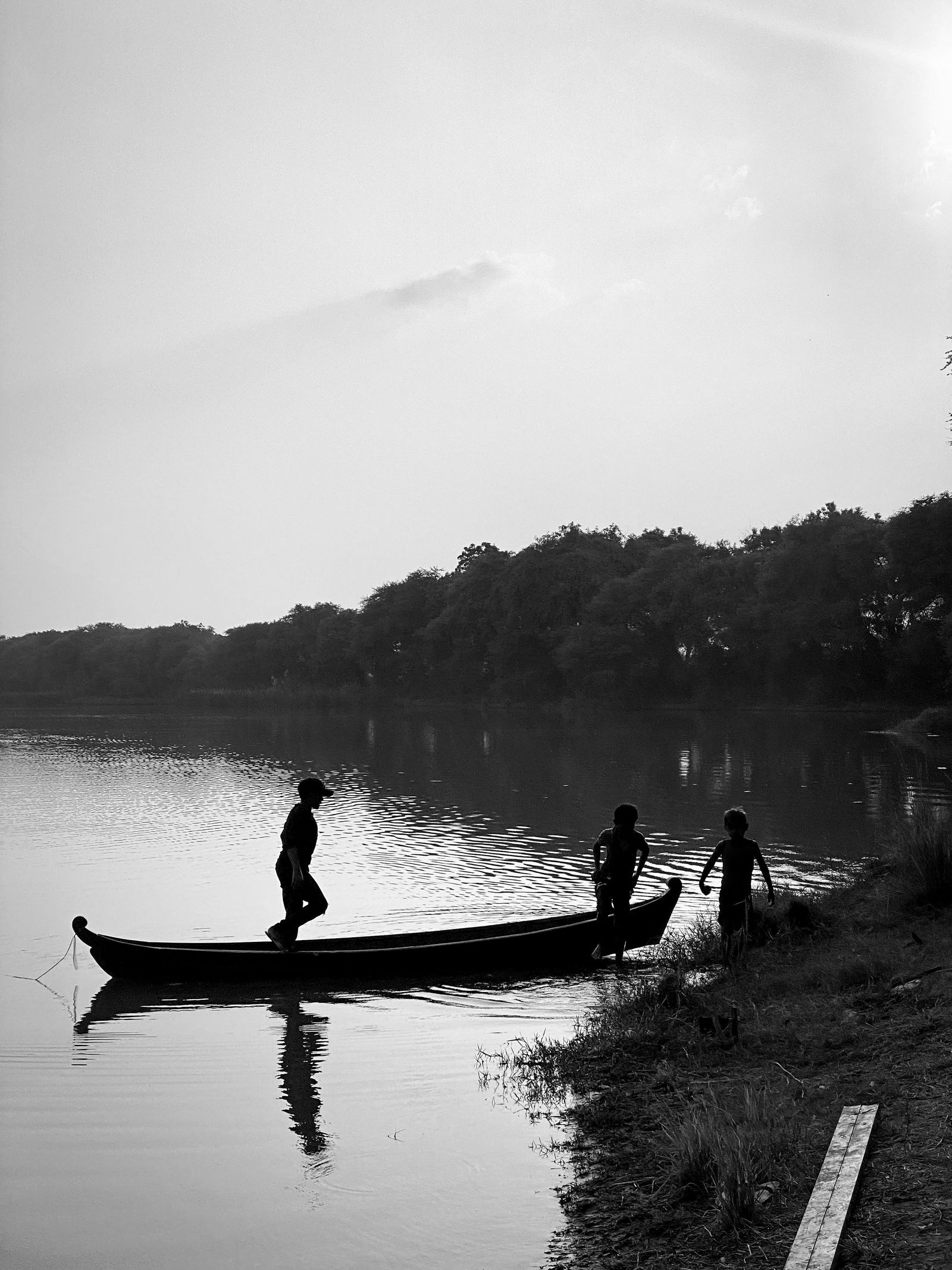 Children by a canoe at the lake shore