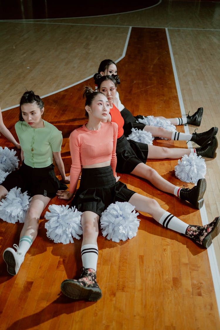 Cheering Squad Sitting On The Floor While Looking Afar