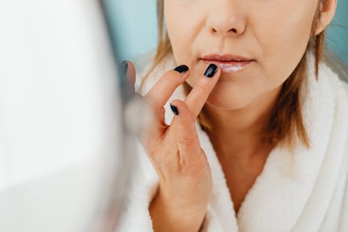 Free A Woman Applying a Cream on Her Lips Stock Photo