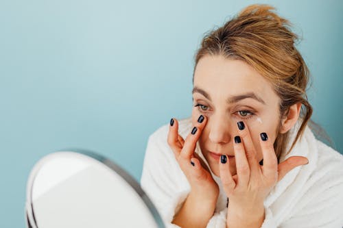 Close up of a Woman Applying Cream on her Face