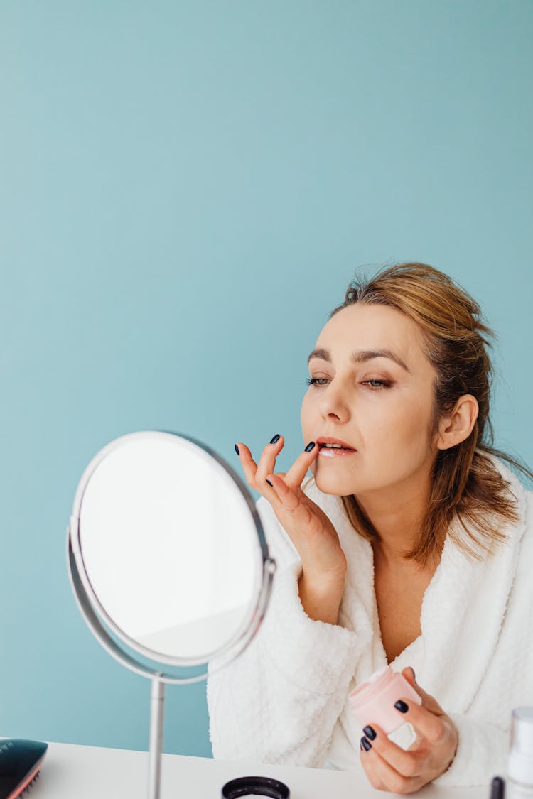 Woman With Black Nail Polish Applying Cream On Lips