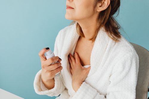 Free A woman wearing a bathrobe applies a skincare product for beauty treatment and relaxation. Stock Photo