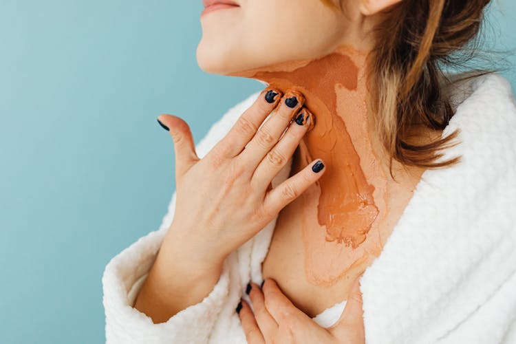 Woman Putting A Skin Treatment Product On Her Neck