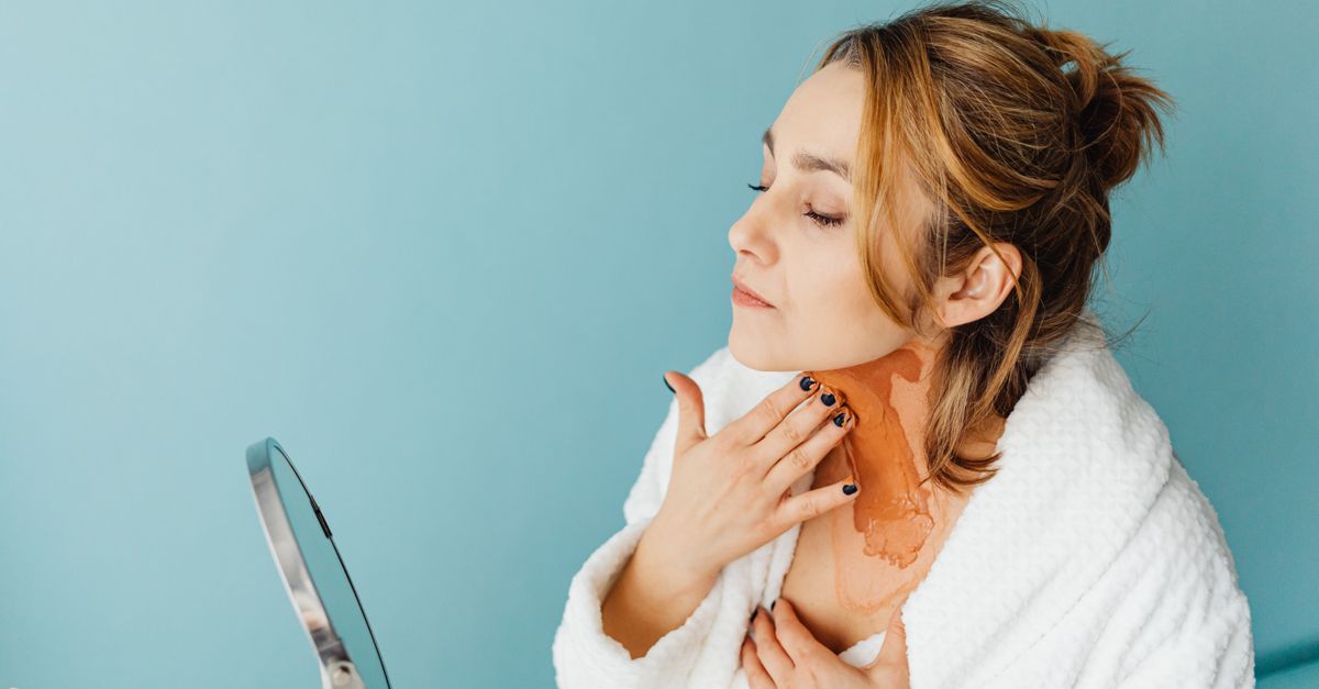 Woman in a white robe applies skincare product in a studio with a blue background. - Evidence evidence guide for astaxanthin skin hydration randomized trial