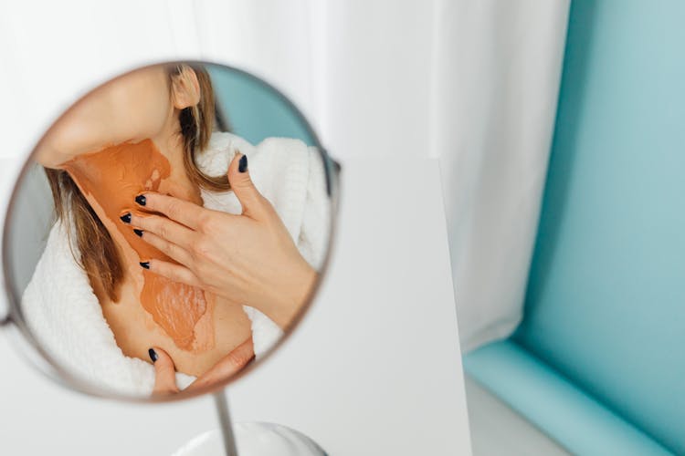 Woman Applying Thick Layer Of Foundation To Her Neck