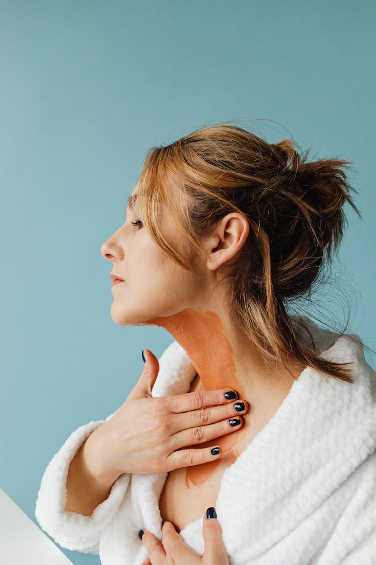 Woman Applying Dark Foundation To Her Neck