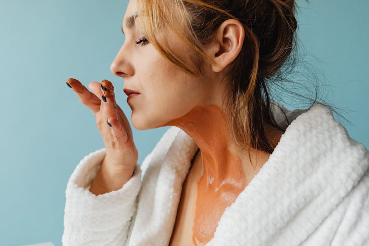 A Woman Smelling Her Hand With Ointment