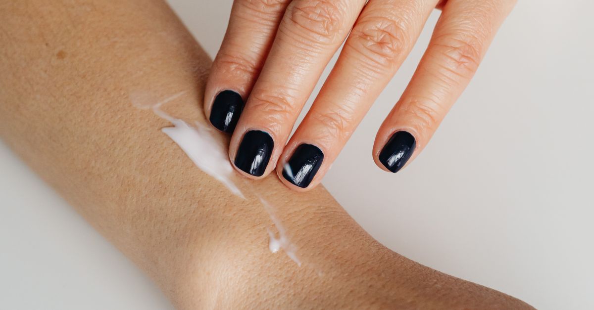 Woman applying cream to her forearm