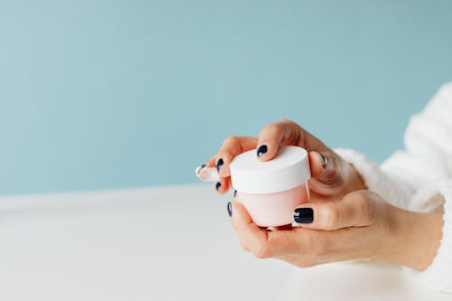 Close-up of Woman Holding a Container with Cream 