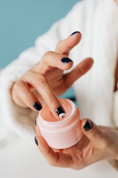 Woman applying cosmetic cream from a jar, showcasing skincare routine.