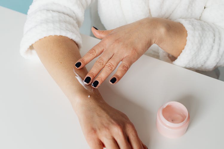 Close Up Photo Of A Person Applying Cream On Her Arm