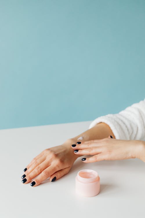 Free Person Applying Cream on Her Arm Stock Photo