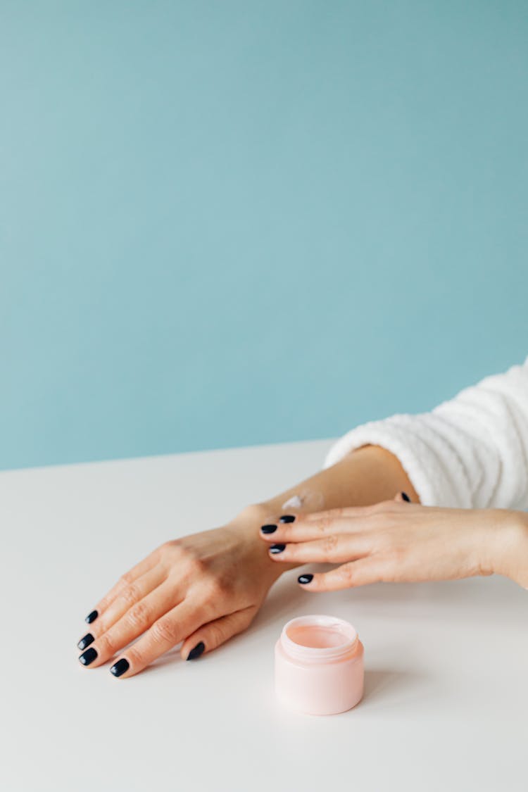 Person Applying Cream On Her Arm