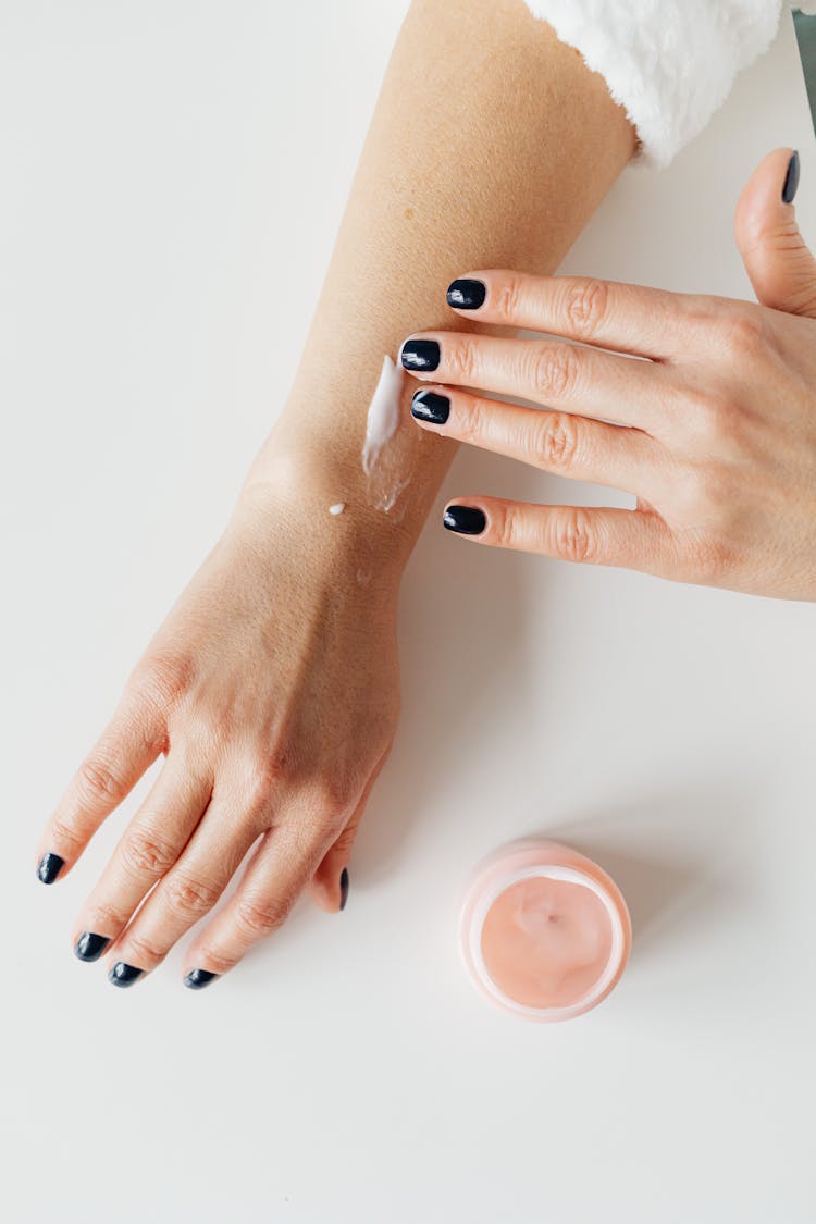 Person Applying Cream On Her Arm