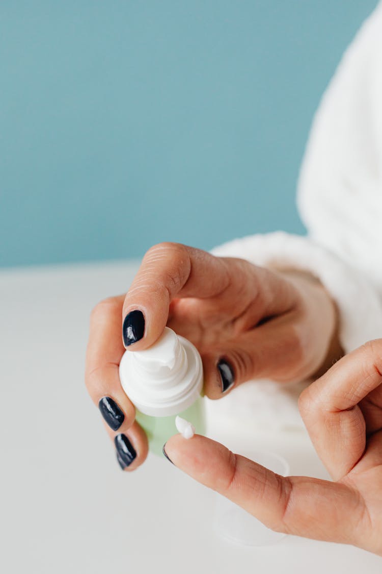 Close-up Of Woman Squeezing Out Cream With A Pump 