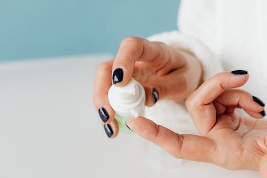Detailed shot of hands applying skincare cream with gentle focus.
