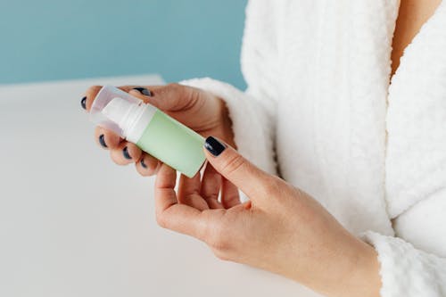 Woman Holding a Skincare Product Bottle in her Hands