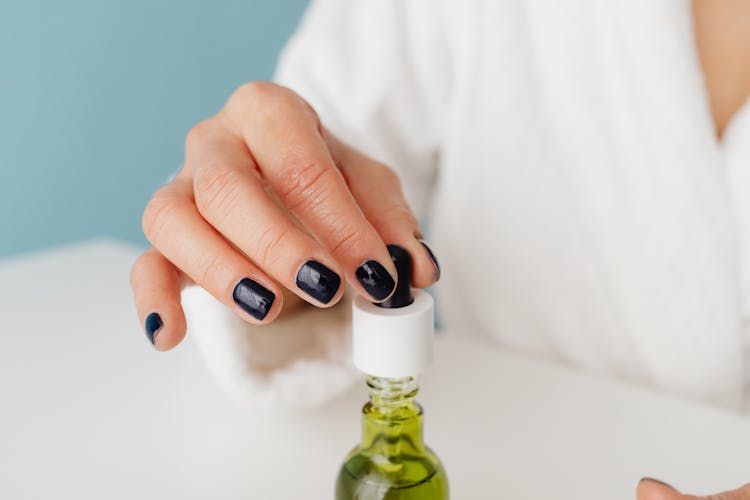 Hand Holding A Clear Dropper Bottle 