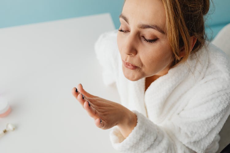 Close-up Of Woman Blowing On Her Freshly Painted Nails 