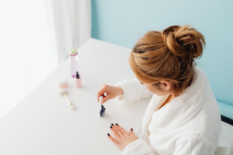 Woman In Bathrobe Painting Her Nails