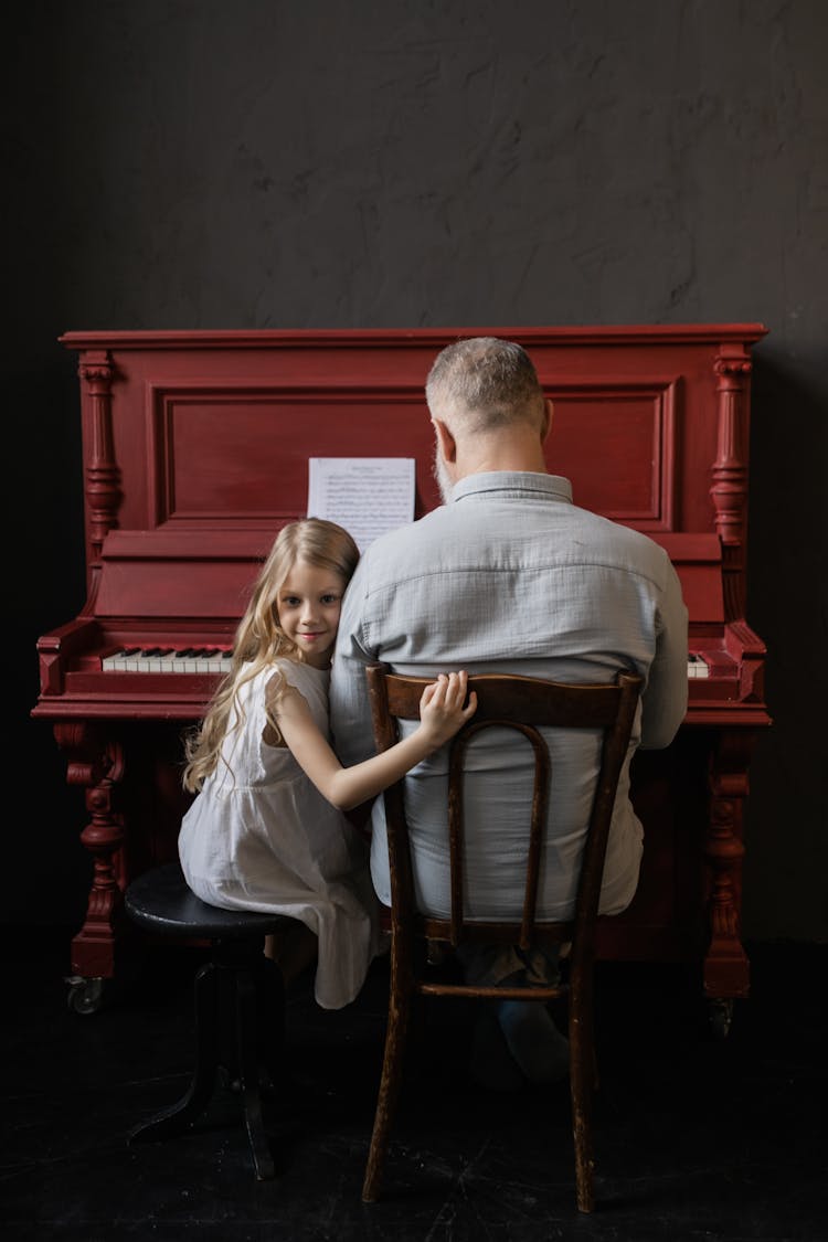 Grandfather And Granddaughter Playing The Piano