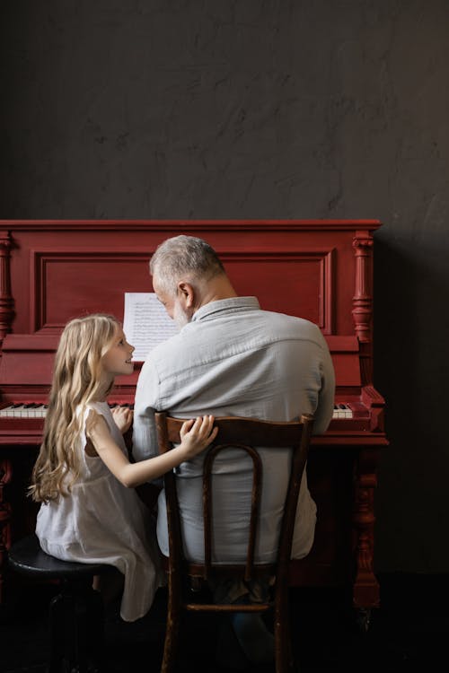 Free Grandfather and Granddaughter Playing the Piano Stock Photo