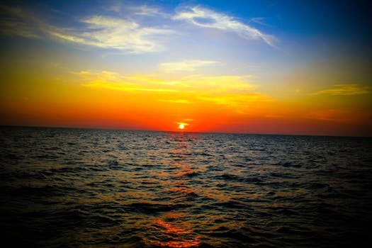 日落倒映在平静的海面上，为海景增添了活力与宁静