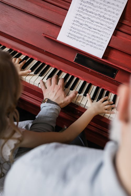 Free People Playing Piano with Sheet Music Stock Photo