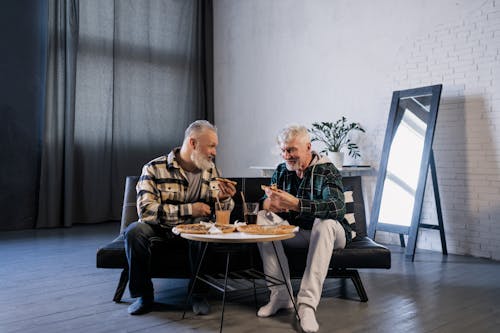 Free Elderly Men Eating while Talking to Each Other Stock Photo