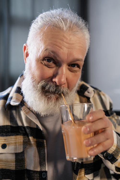 Elderly Man in Plaid Shirt Drinking