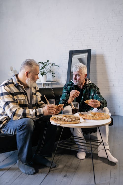 Elderly Men Eating while Talking to Each Other