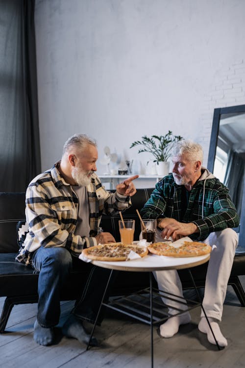 Elderly Men Eating while Talking to Each Other