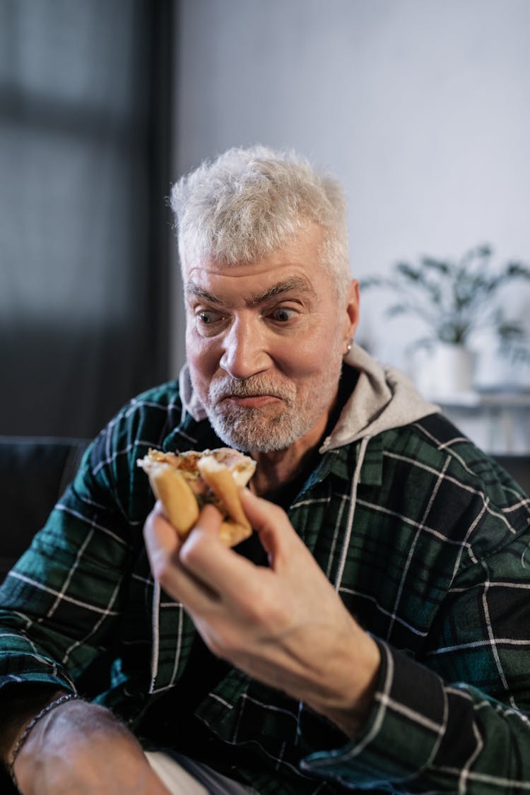 Elderly Man In Plaid Shirt Eating Pizza