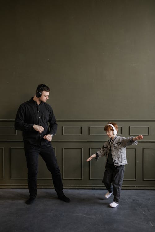 Free Father and Son Dancing while Listening to Music Stock Photo