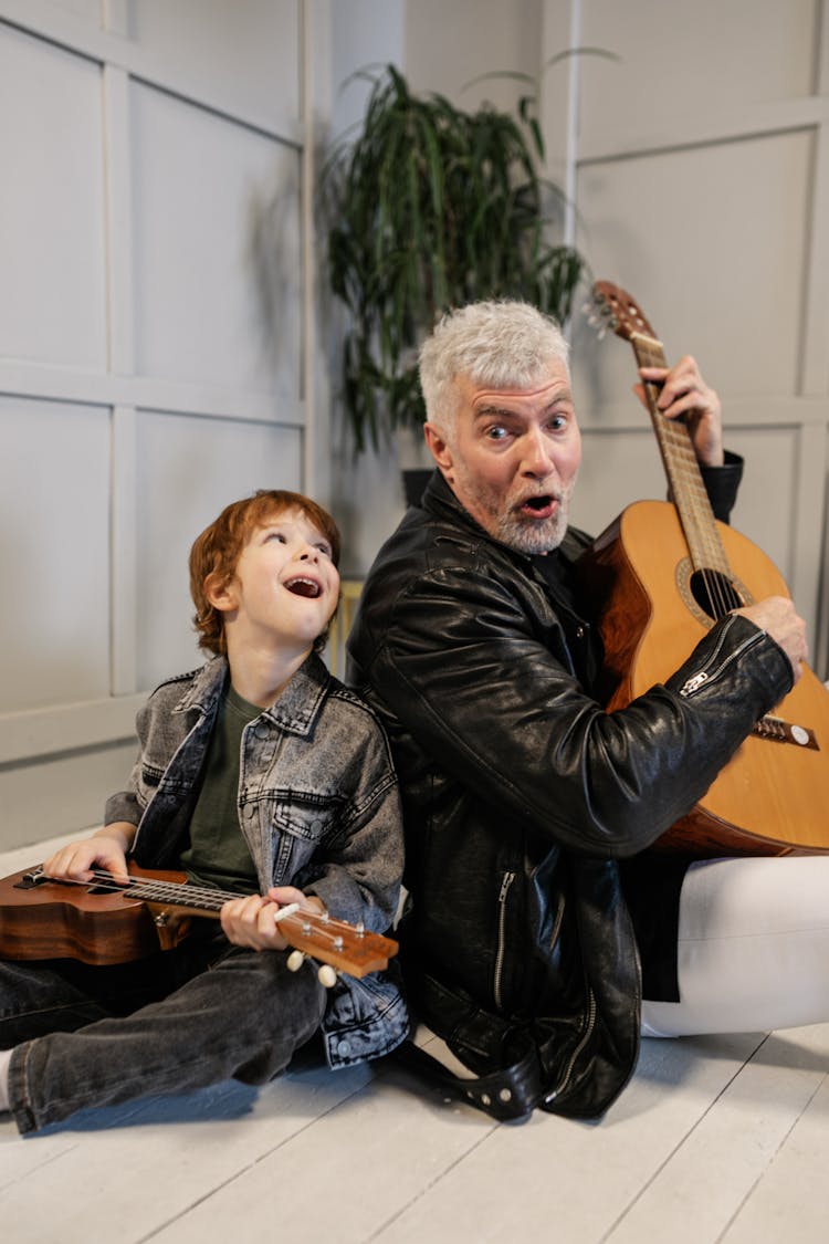 Grandfather And Grandson Holding Their String Instruments