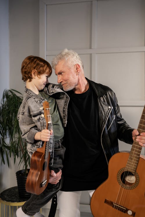 Grandfather and Grandson Holding Their String Instruments while Looking at Each Other